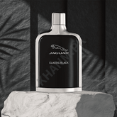 Jaguar Classic Black perfume bottle on a textured surface with a dark background