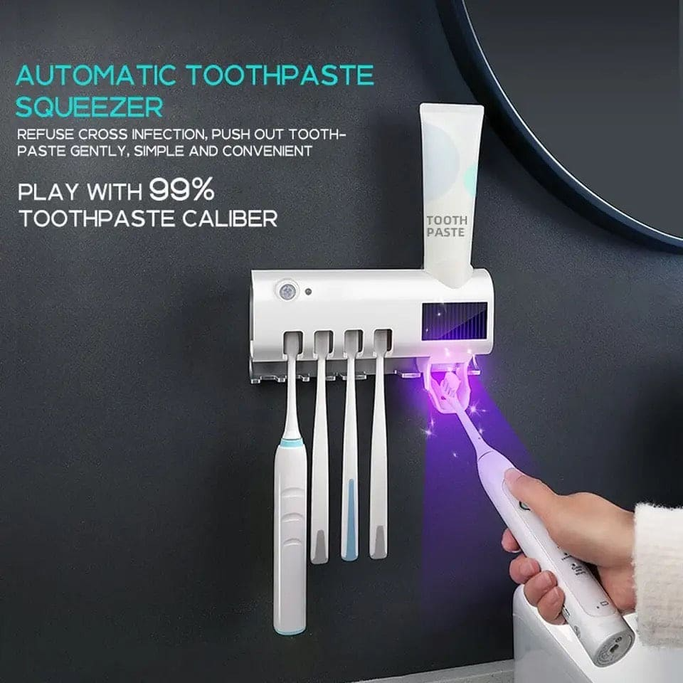 Automatic toothpastequeezer with toothbrushes and a hand holding a UV light device on a dark background.