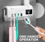 Electric toothbrush holder with toothbrushes and a hand using one, mounted on a gray wall.