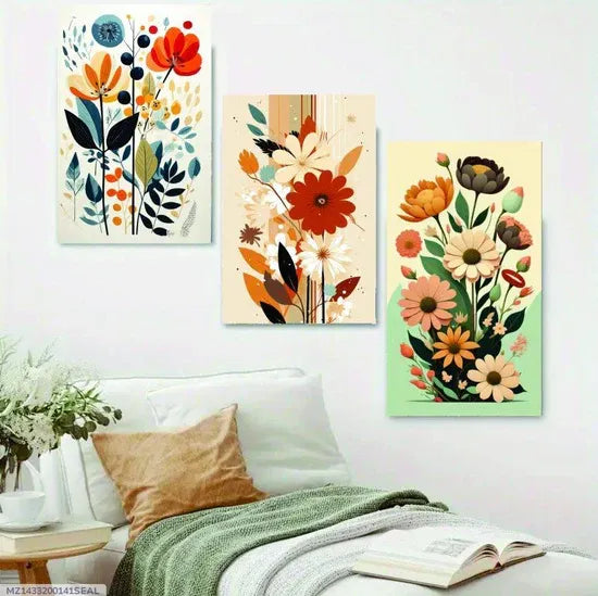 Three floral art prints on a wall above a sofa with a plant and coffee table.