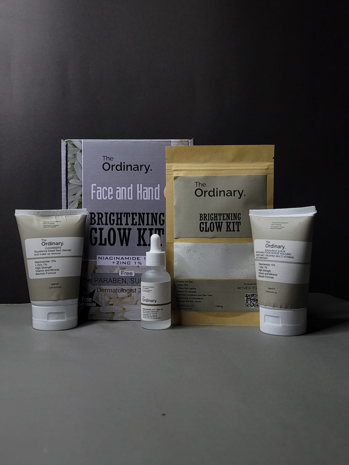 The Ordinary skincare products including face and hand cream, serum, and packaging on a dark background