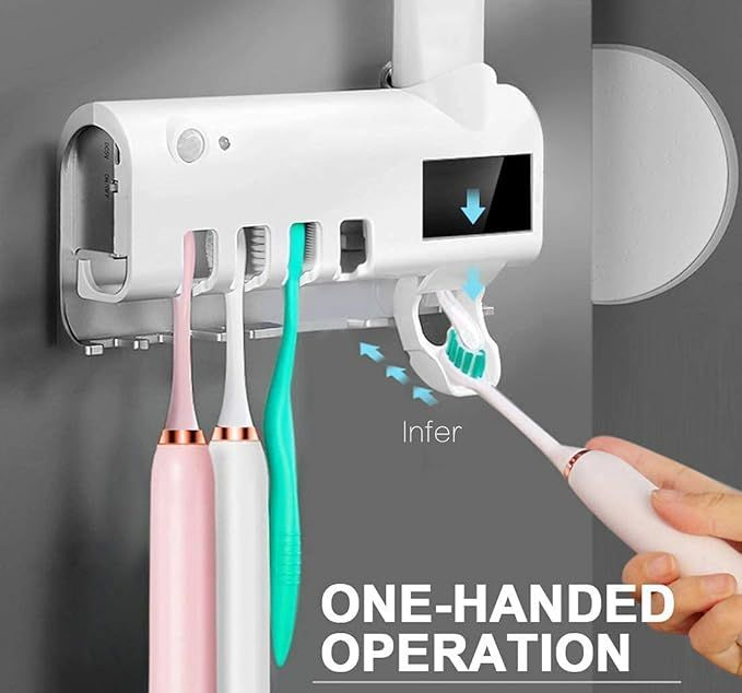 Electric toothbrush holder with toothbrushes and a hand using one, mounted on a gray wall.